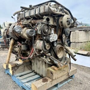 A large engine sitting on top of a wooden crate.