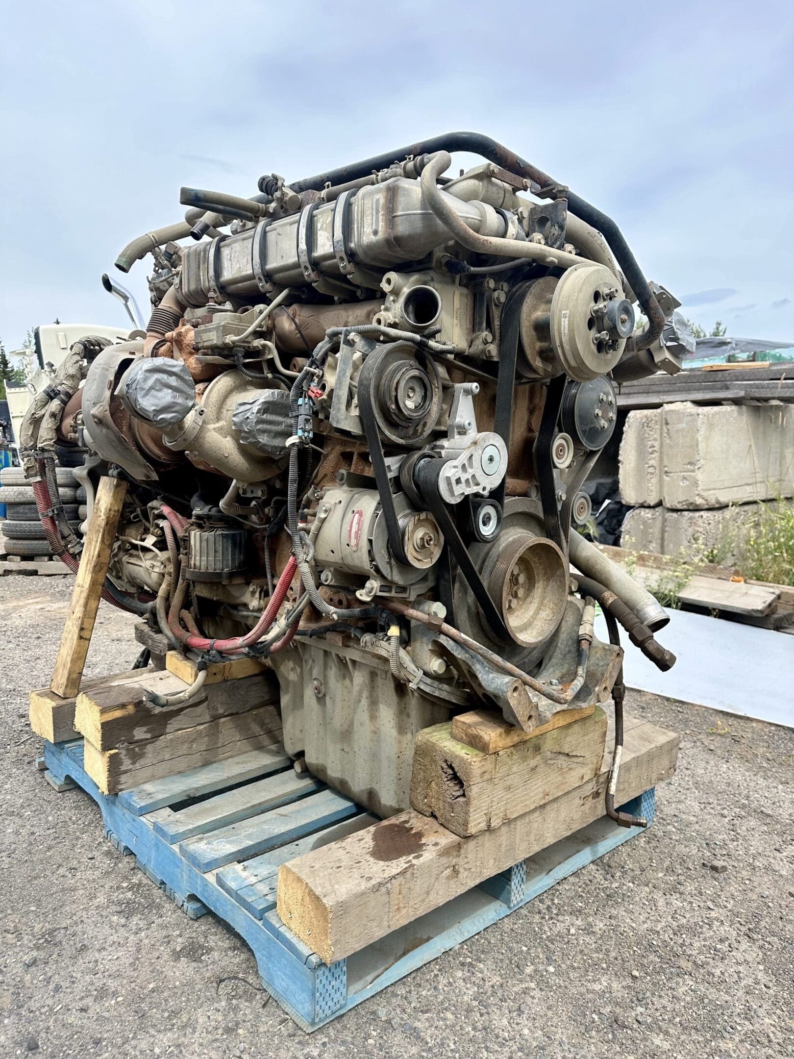 A large engine sitting on top of a wooden crate.