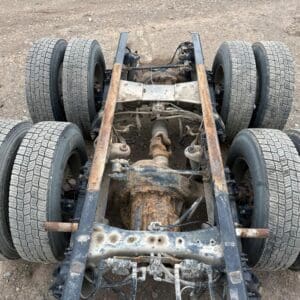 A truck frame with four tires on it.