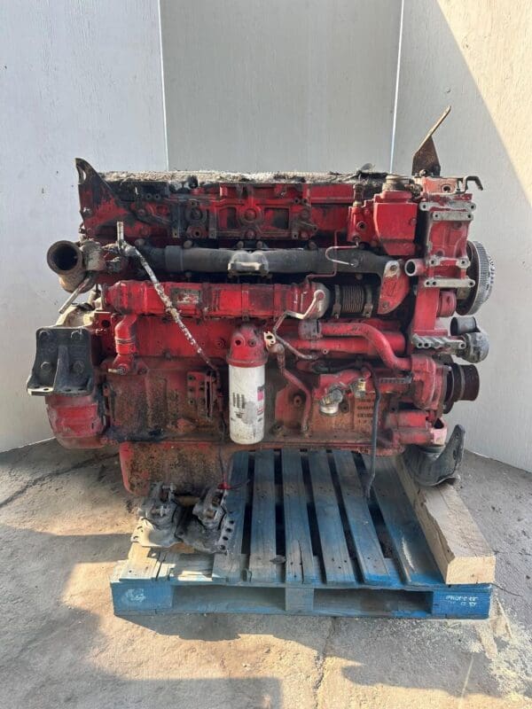 A red truck engine sitting on top of a pallet.