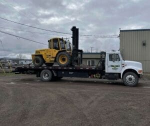 A large truck with a yellow and black tractor on it